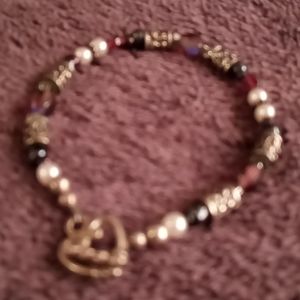 Women's bracelet. Mostly silver w blue,purple red beads w a heart clasp